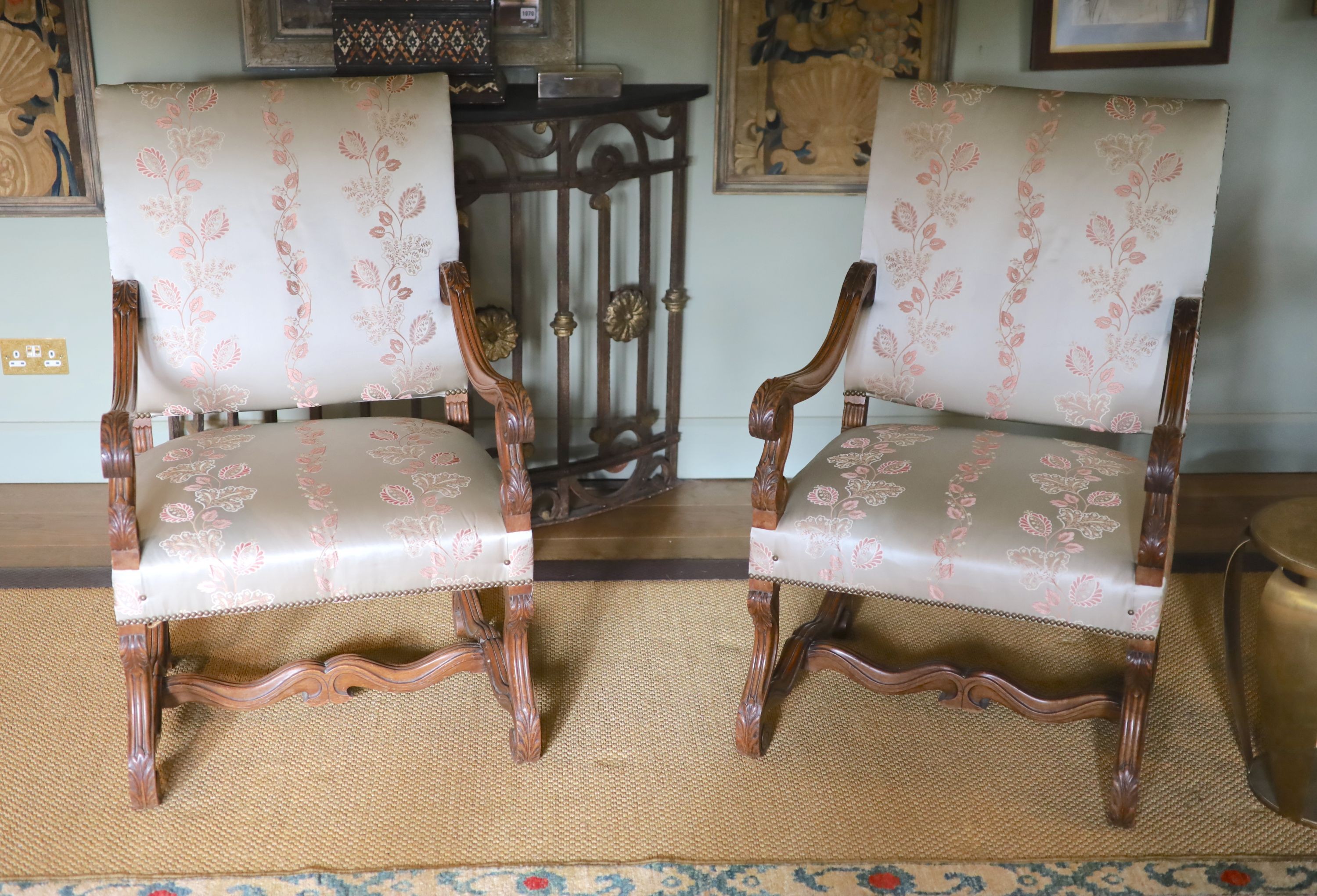 A pair of French carved walnut fauteuils, with machine embroidered Eau de Nil silk upholstery, width 66cm height 106cm